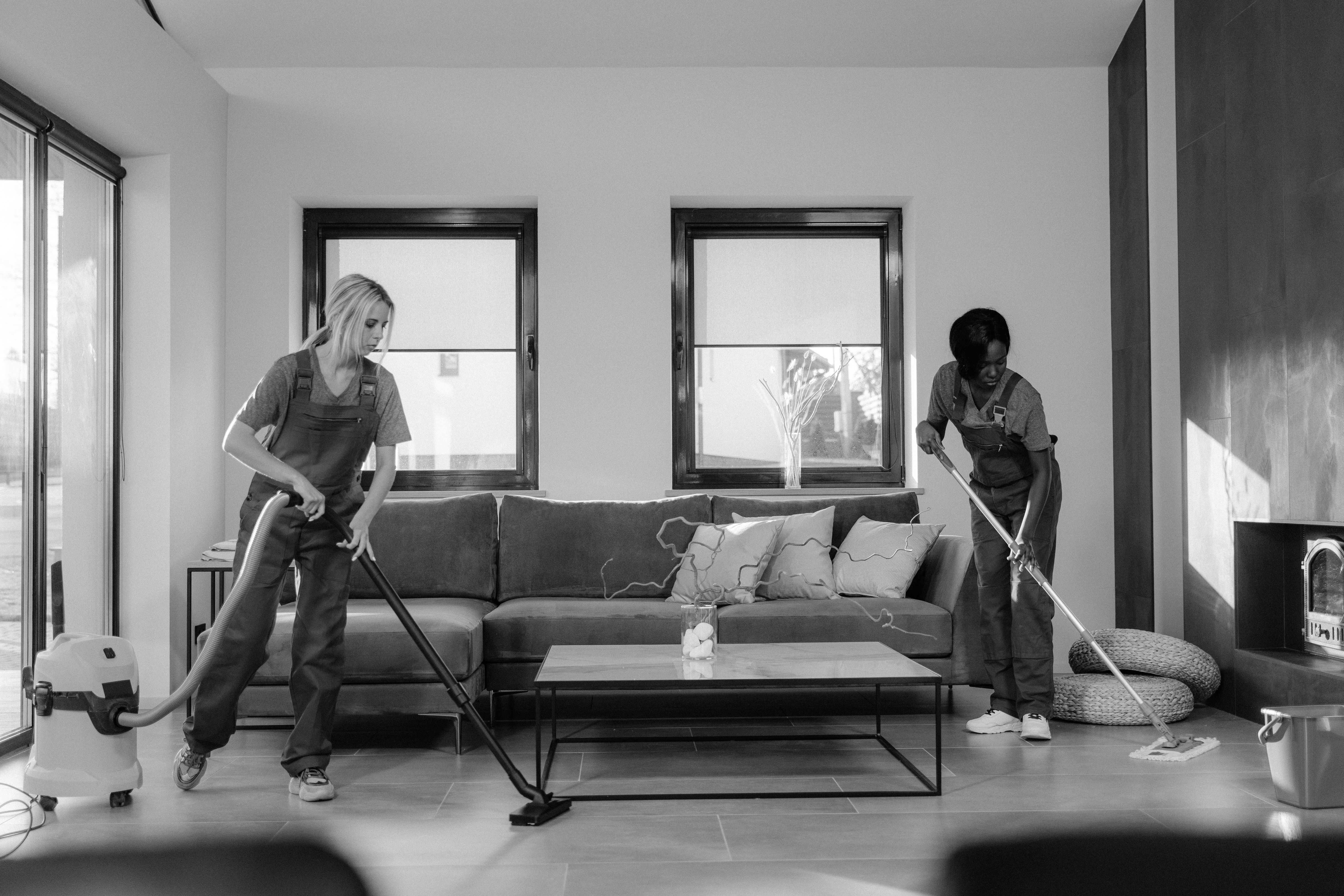 A picture of two people cleaning up a living room.