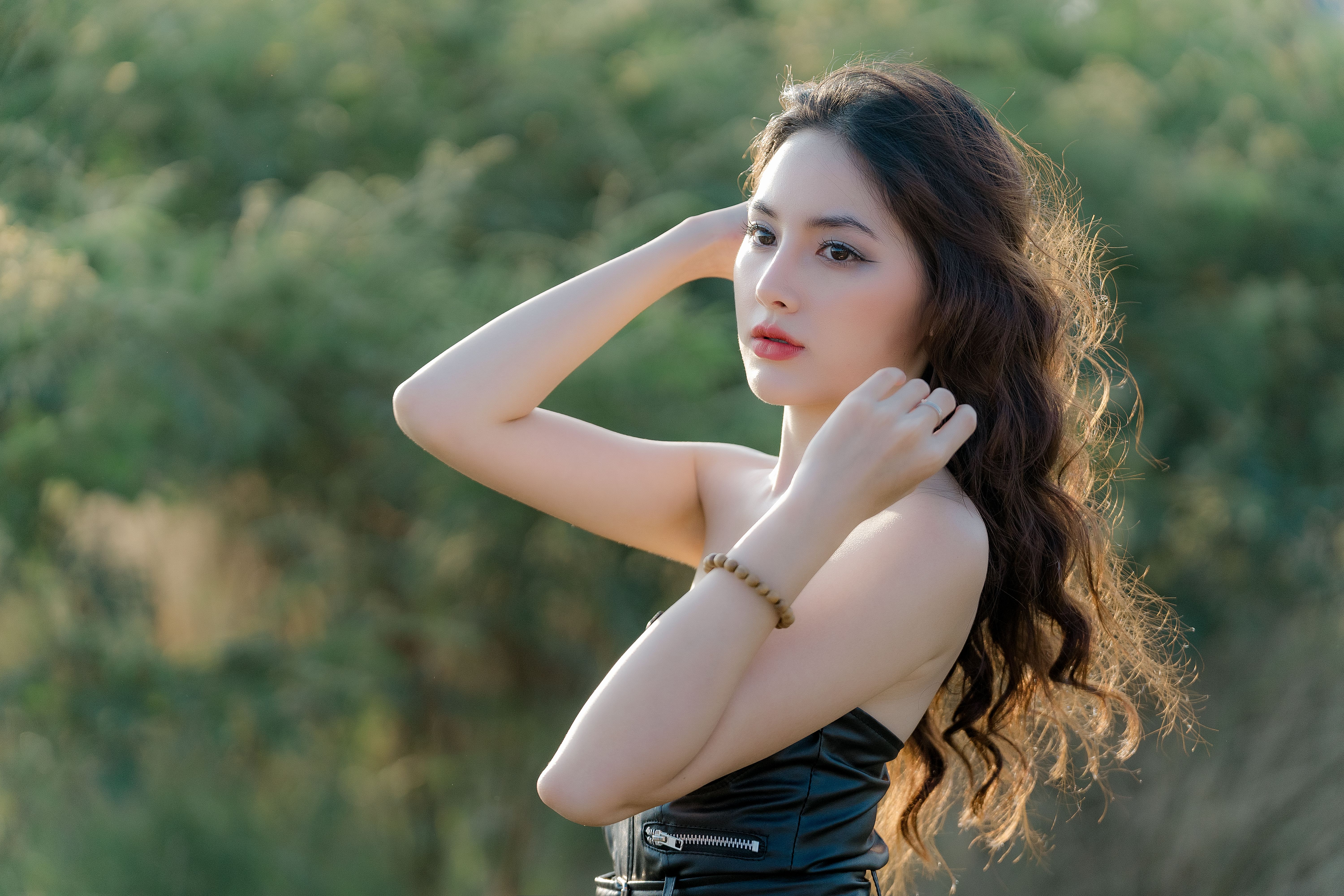 A picture of a woman with make up on in front of a forest